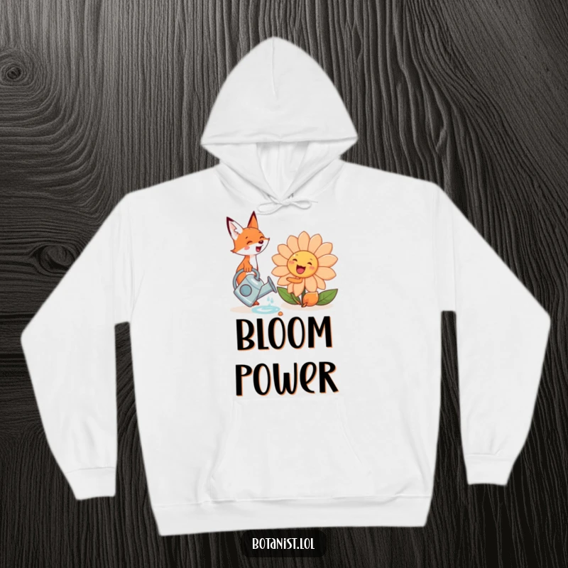 A cute, funny fox excitedly watering a giant, smiling flower, printed on a soft and cozy hoodie.