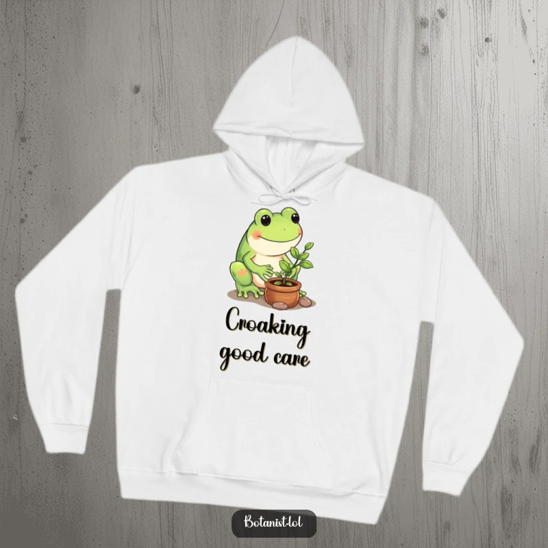 Funny hoodie featuring a playful frog carefully nurturing a tiny potted sapling, embodying gentle care.