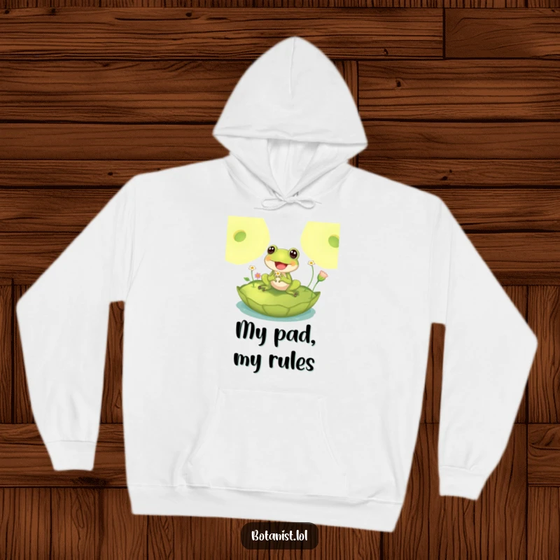 Funny hoodie design featuring a delighted frog sitting on a large lily pad, inspecting tiny flowers with utmost joy and relaxation.