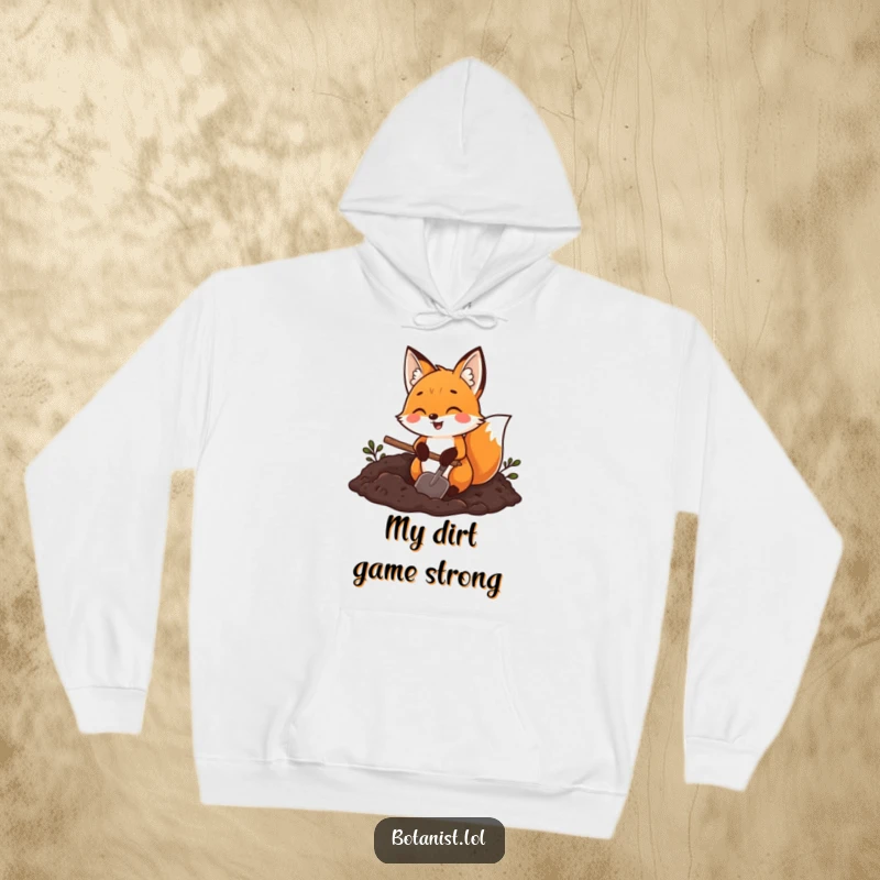Funny fox gardener hoodie, a joyful fox with a trowel digging in rich dark soil, providing warmth and outdoor charm.