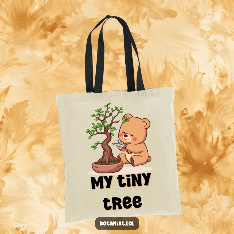Funny tote bag featuring a bear carefully pruning a bonsai tree with tiny scissors, showcasing a peaceful yet humorous scene.